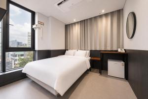a bedroom with a large white bed and a window at Jongno The Stay Korea in Seoul