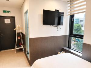 a bedroom with a bed and a flat screen tv on the wall at Jongno The Stay Korea in Seoul +19 photos