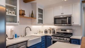 a kitchen with white cabinets and a stove top oven at The Top Shelf by AvantStay in Paso Robles