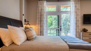 a bedroom with a bed with a large window at Paso Park Suites by AvantStay in Paso Robles