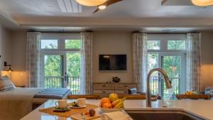 a kitchen and living room with a bed and windows at Paso Park Suites by AvantStay in Paso Robles