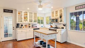 a kitchen with white cabinets and a ceiling fan at Summer Place by AvantStay in Templeton