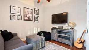 a living room with a couch and a tv and a guitar at Summer Place by AvantStay in Templeton