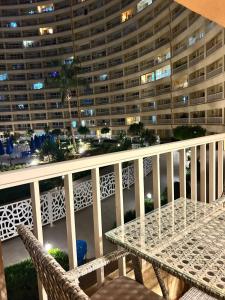 a balcony with a table and chairs and a large building at Nashwa m mohamed in Ain Sokhna