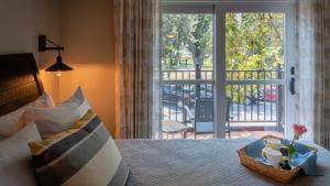 a bedroom with a bed and a door with a balcony at Paso Park Suites by AvantStay in Paso Robles