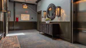 a hallway with a mirror on the wall and a table at Paso Park Suites by AvantStay in Paso Robles +16 photos