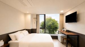 a hotel room with a bed and a window at Jongno The Stay Korea in Seoul
