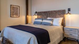 a bedroom with a large bed with blue and white pillows at Paso Park Suites by AvantStay in Paso Robles