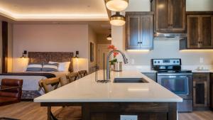 a kitchen with a sink and a bed in a room at Paso Park Suites by AvantStay in Paso Robles