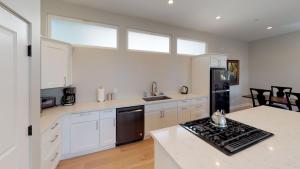 a kitchen with white cabinets and a stove top oven at Twice is Nice by AvantStay in Paso Robles