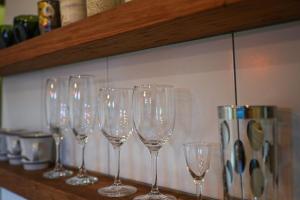 a row of wine glasses sitting on a shelf at Moon's Cafe in Onomichi