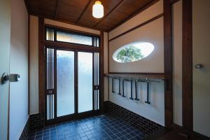a bathroom with a window and a tile floor at Moon's Cafe in Onomichi