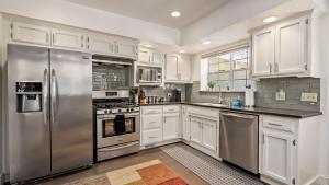 a kitchen with white cabinets and stainless steel appliances at Chateau Paso by AvantStay in Paso Robles