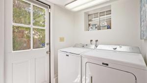 a white laundry room with a washing machine and a window at Chateau Paso by AvantStay in Paso Robles +25 photos