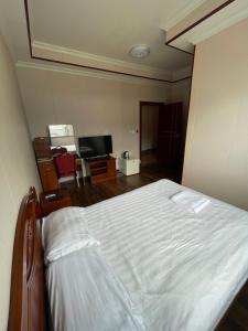 a bedroom with a bed and a flat screen tv at CHINA STAR HOTEL in Kolonia