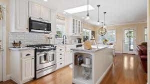 a kitchen with white cabinets and a stove top oven at 13th Street Retreat by AvantStay in Paso Robles