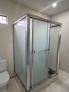 a glass shower in a bathroom with a toilet at AG3K Oasis in Buccoo +5 photos