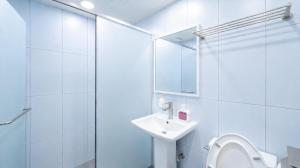 a white bathroom with a sink and a shower at Jongno The Stay Korea in Seoul