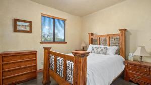 a bedroom with a wooden bed and a window at Vita Amorosa by AvantStay in Atascadero