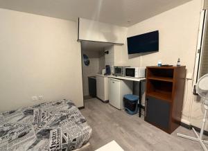 a room with a bed and a desk with a microwave at Ocean 300m Gare Centre ville Wifi Parking gratuit in Belfort