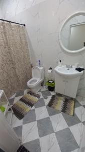 a bathroom with a toilet and a sink and a mirror at Tam-Toboyah in Conakry