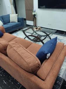 a brown couch sitting in a living room with a table at Tam-Toboyah in Conakry