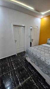 an empty room with a bed and a door at Tam-Toboyah in Conakry