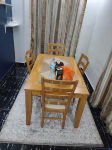 a wooden table with chairs and a bottle of water at Tam-Toboyah in Conakry +7 photos