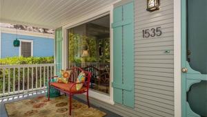 a front porch with a red chair and a house at The Sycamore by AvantStay in Paso Robles