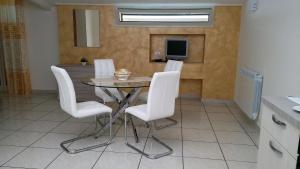 a dining room with a table and white chairs at B&B Le Tre Gemme Junior in Lentini