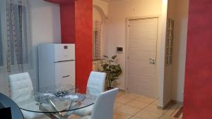 a dining room with a glass table and white chairs at B&B Le Tre Gemme Junior in Lentini