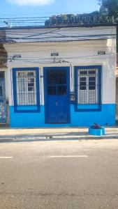 a blue and white building with a blue door and windows at Quartos privativos - São Domingos, Niterói in Niterói