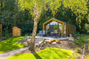 a small wooden cabin with a table and a tent at Landal Namur Nature in Gesves +7 photos