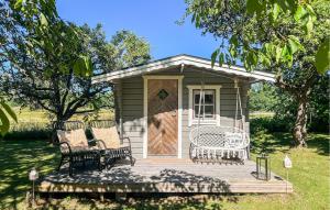 a small shed with two chairs and a door at 2 Bedroom Lovely Home In Ödeshög in Ödeshög +15 photos