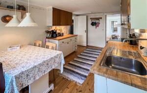 a kitchen with a sink and a table in it at 2 Bedroom Lovely Home In Ödeshög in Ödeshög