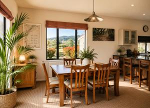 a kitchen and dining room with a wooden table and chairs at Mountain View Retreat in Hokitika