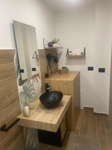 a bathroom with a black bowl sink on a wooden counter at La Via delle Rose in Alimena