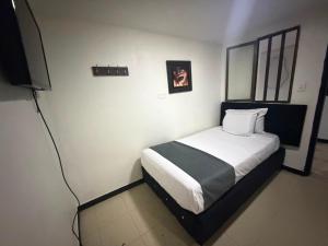 a bedroom with a bed and a television in it at Hotel Nexo in Medellín