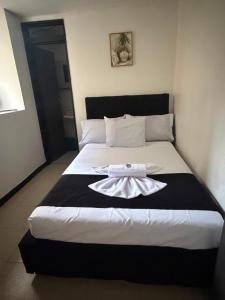 a bedroom with a bed with a robe on it at Hotel Nexo in Medellín