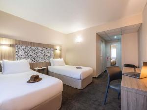 a hotel room with two beds and a desk at Ibis Styles Lyon Gorge de Loup Saphir in Lyon +66 photos