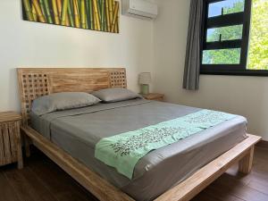 a bed in a bedroom with a wooden headboard at Faré Pépénai in Avatoru