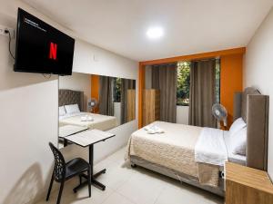 a hotel room with two beds and a flat screen tv at Hospedaje ALETHIA in Huacho
