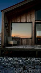 a chair sitting on the porch of a building at Cabañas Julián Elías Roja in Puerto Natales +5 photos