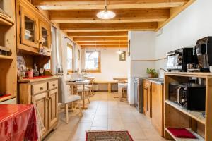 a kitchen with wooden cabinets and a dining room at Chalet - Margherita in Sappada +9 photos