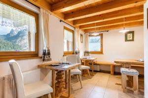 a dining room with wooden ceilings and a table and chairs at Chalet - Margherita in Sappada