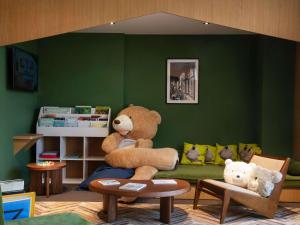 a room with two large teddy bears sitting on a couch at Novotel Nice Aéroport Cap 3000 in Saint-Laurent-du-Var