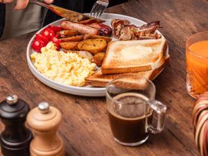 a plate of breakfast food with eggs sausage and toast at Novotel Rouen Sud Zenith Parc Expo in Saint-Étienne-du-Rouvray