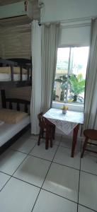 a table and bench in a room with a window at Pousada Anjo Gabriel in Penha
