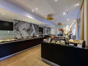a restaurant with a counter with food on display at Mercure Aachen Europaplatz in Aachen