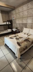 a bedroom with a large bed and a table at Pousada Anjo Gabriel in Penha